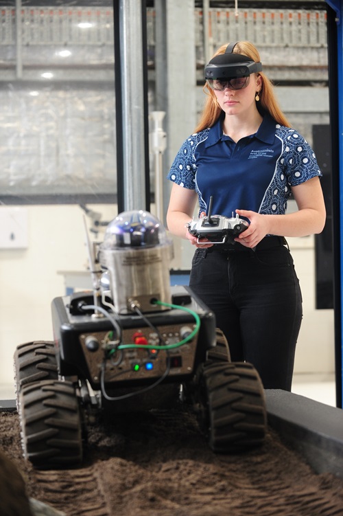 Woman operting robot over gritty uneven surface