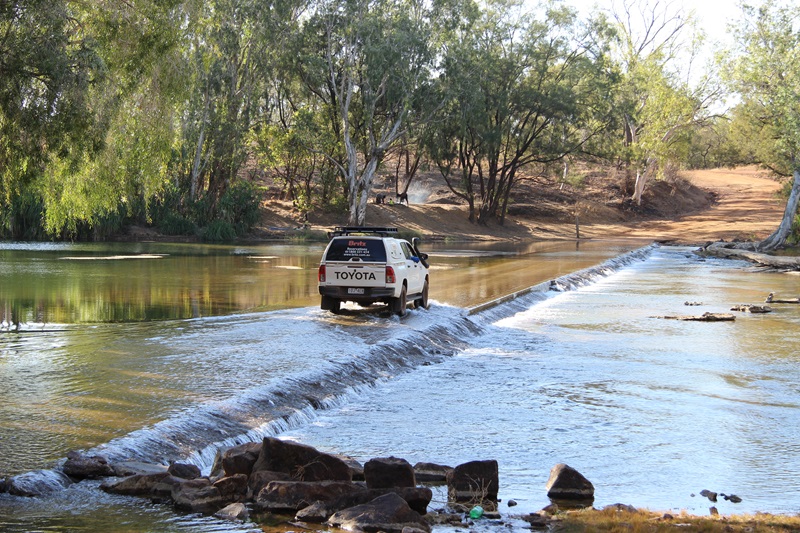 A white Toyota ute drives across a culvert on the Roper River, Northern Territory.
