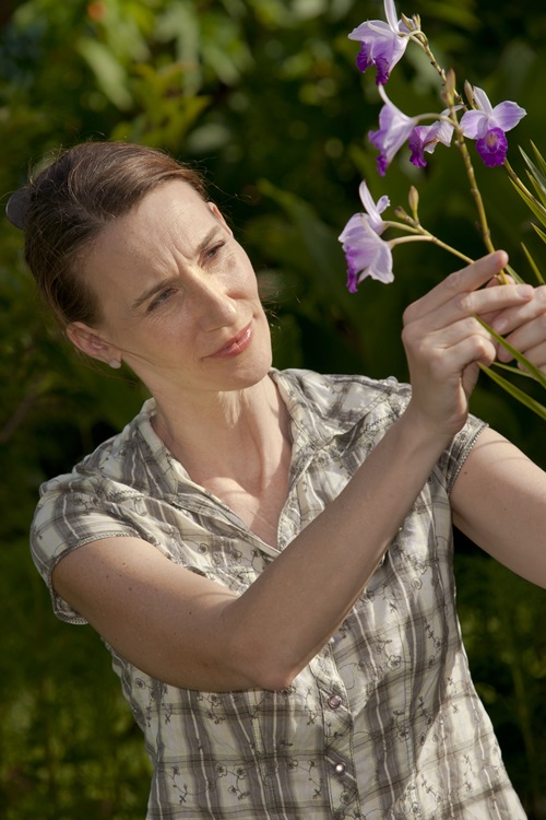 CSIRO's Dr Katharina Nargar observing a purple flower. 