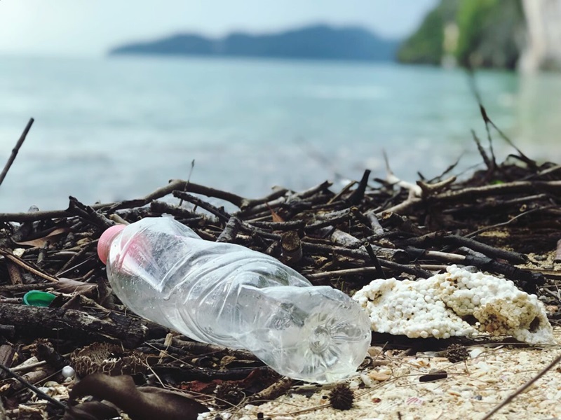 Plastic bottle on beach in front of water