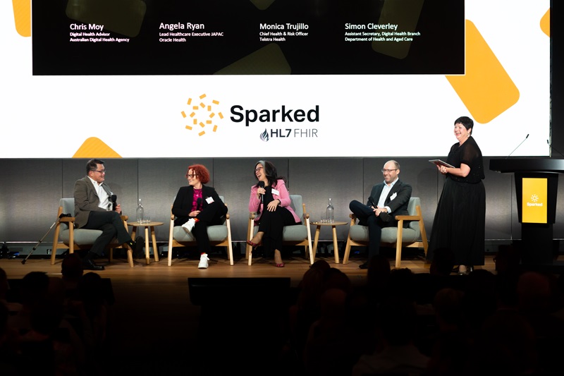 Group of people on a stage in front of a Sparked banner