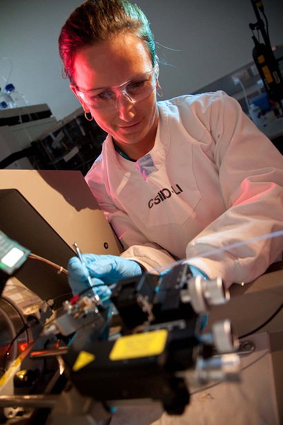 A female scientist puts a sample into a machine to analyse it