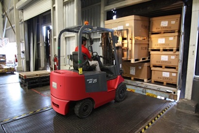 A forklift removes pallets in a warehouse