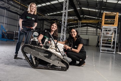 Three researchers pose with a robot. 