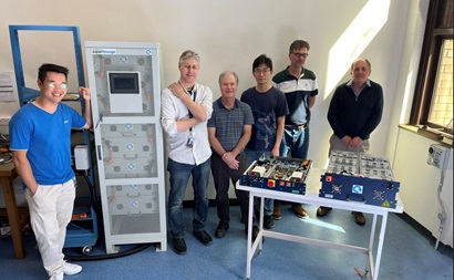 The BMS Team poses with equipment inside an office. 