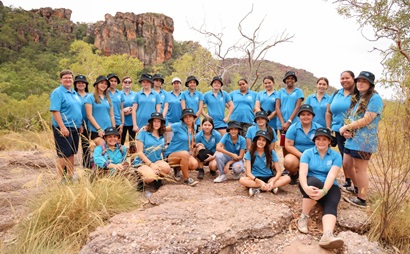 A group of young women in blue tshirts pose for a photograph on Country. 