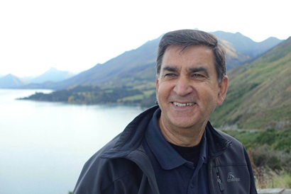 Rai Kookana in front of a lake and mountains in New Zealand