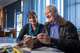 Scientist and teacher sitting at desk together working