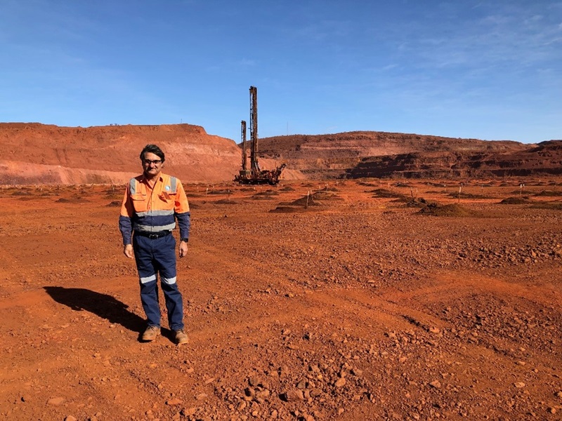 man stands among red soils