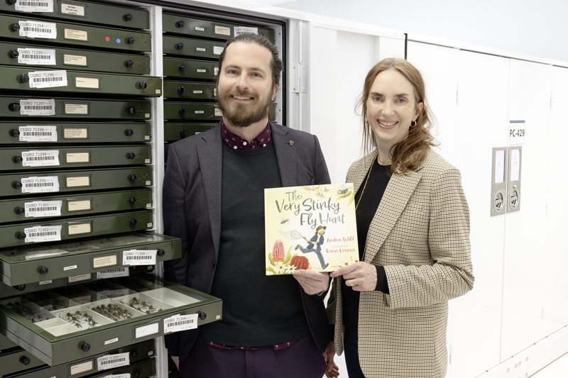 Author Andrea Wild (right) and Keith Bayless with The Very Stinky Fly Hunt book in the Australian National Insect Collection, Diversity Building