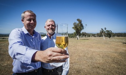 Phil Larkin and Crispin Howitt in the Canberra fields, with the world's first gluten-free barley beer.