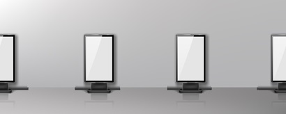 Image shows a row of four digital billboards lined up against a grey wall. The digital billboards have a white screen and a black frame, the look similar to a television, or computer monitor.