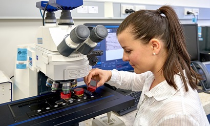 Female researcher in lab testing coal. 