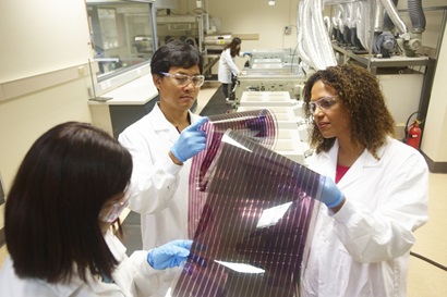 Printed solar film testing - a group of three scientists in a lab inspecting the solar film