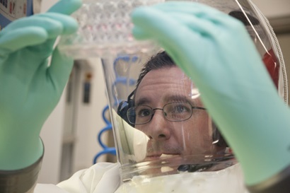 A CSIRO scientist working at the highest level of biosecurity in a protective suit