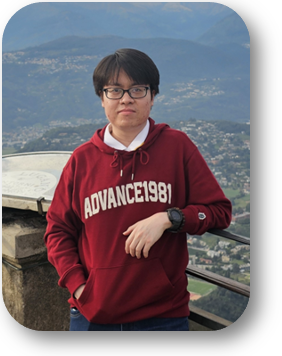 A man in red sweatshirt standing in front of a fence.