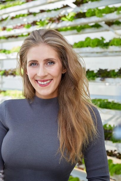 Sam Bartels standing in front of vertical harvest system