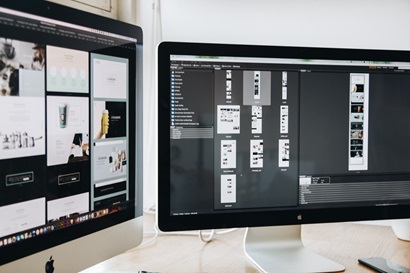 Two computer screens showing design layouts for web pages. 