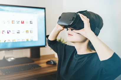 Woman wearing virtual reality goggles in her modern studio.