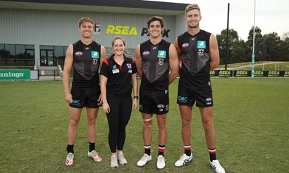 One female and three males on a football pitch 