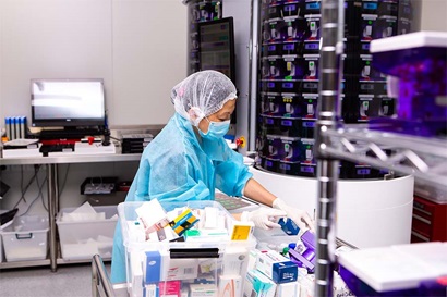 Person packing medication in laboratory.
