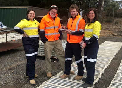 Two females and two males standing outside wearing hi-vis tops.
