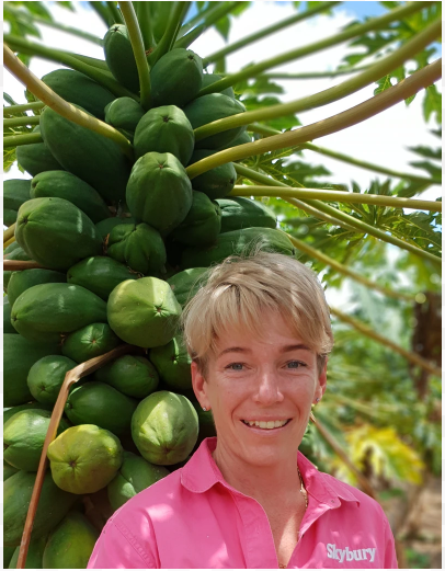 Female standing in front of a papaya tree
