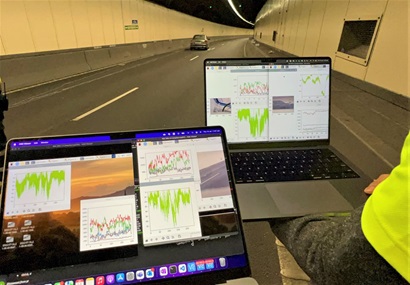Car in a tunnel and computer screens showing data.