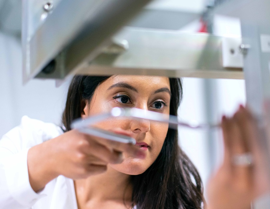 Women operating lab instrument