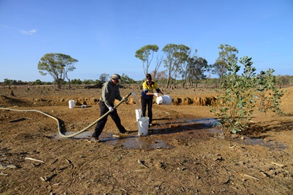 Two CSIRO staff collecting samples of stygofauna from water bores with pump hoses and buckets in the Beetaloo Sub-basin in the Northern Territory 