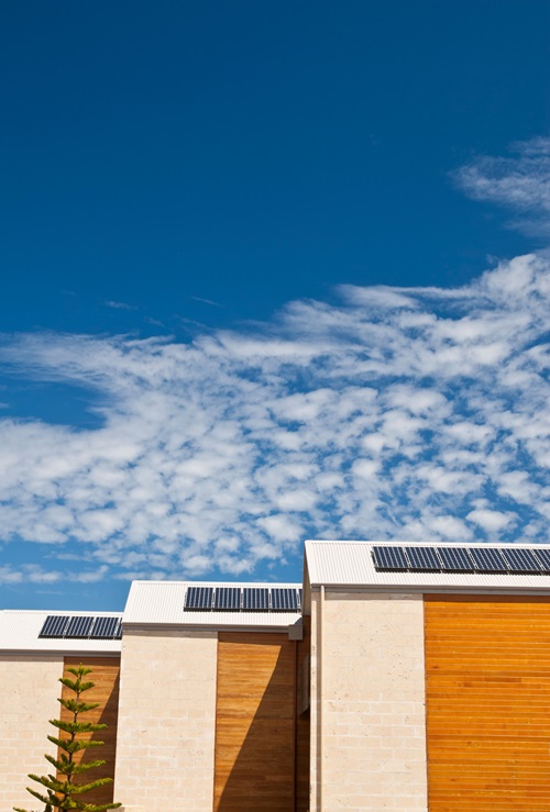 Solar panels on a roof and blue sky above.