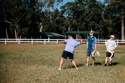 Students are learning about boomerang physics and testing their throws alongside team leader Zac