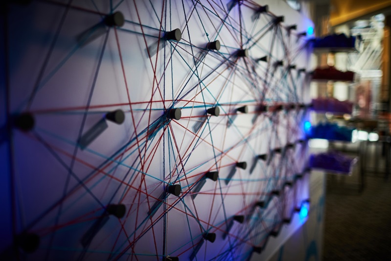 Photo of a board on wall with pins and and connected strings