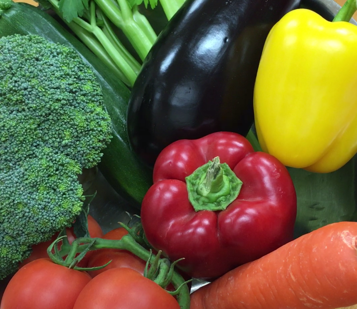 Photograph of a variety of fresh vegetables including celery, eggplant, yellow and red bell peppers, tomatoes, and a carrot.