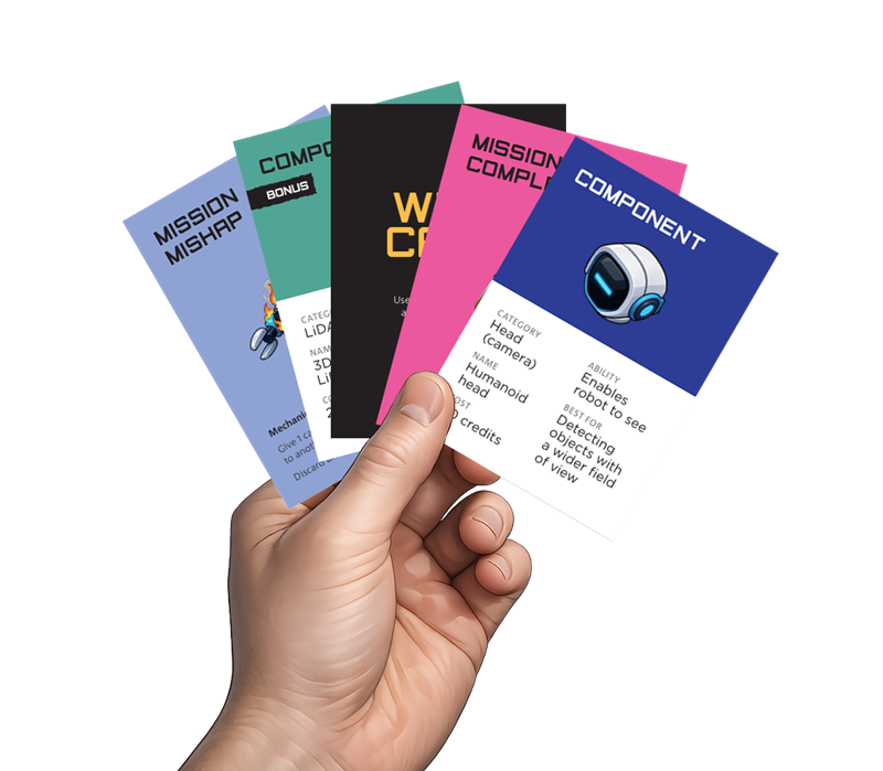 Photograph of a hand holding five colourful cards fanned out, each labelled with different categories such as "COMPONENT" and "MISSION." Cards feature small illustrations, category titles, and descriptive text outlining abilities or mission details, with colours including blue, pink, teal, and black.