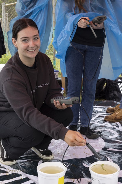 A female Deadly in Generation STEM participant holding a measuring device and smiling