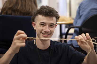 Deadly in Generation STEM participant holding string and smiling