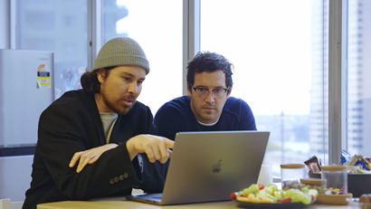 Art Director Michael Lakin and CEO Jonty Hardy sitting at a desk looking at a laptop