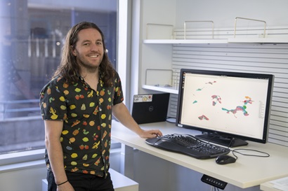 Dr Peter Hickey next to a computer monitor.