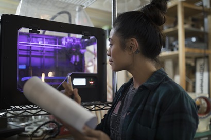 Woman looking at 3D printer