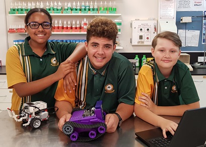 Three Thuringowa State High School student standing in lab with a laptop and robots in front of them