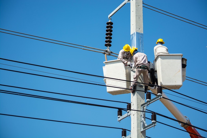 Men on cherry picker working with power lines at Nakhon Ratchasima, Thailand. Image by Thampapon Otavorn, Pexels