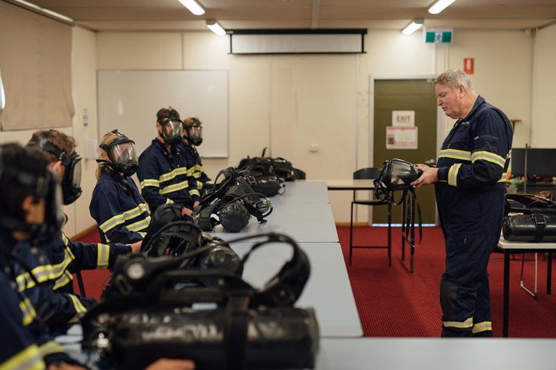 People in PPE gear watching an instructor 