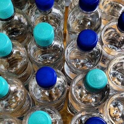Plastic eater bottle with green and blue lids.