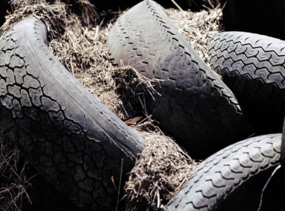 A group of black and used dumped tyres. 