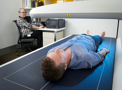 A man lying on the DEXA machine having his body composition measured. 