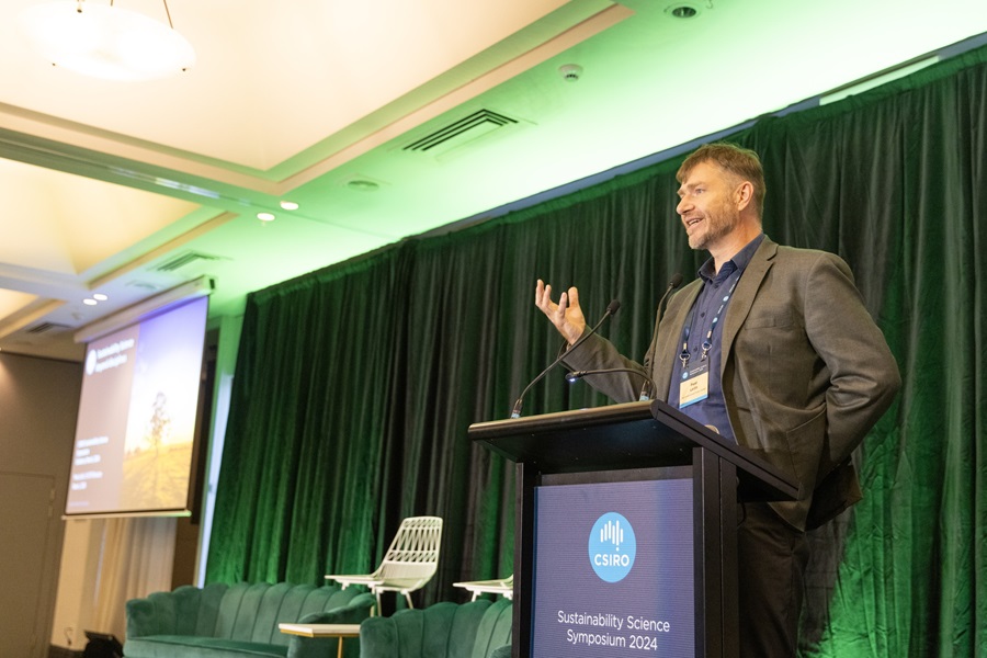 Peat Leith standing behind a lectern talking at the 2024 Sustainability Science Symposium