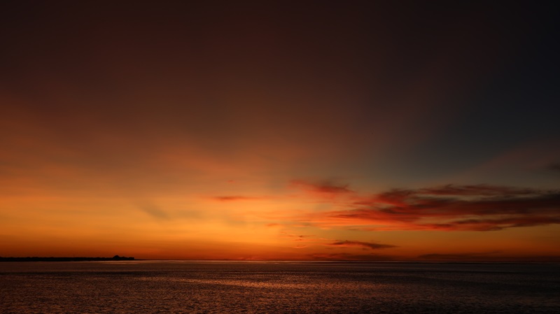 Sunset over the water, orange, red and yellow. 