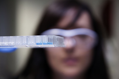 scientist in safety glasses holding antiviral samples