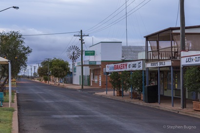 View of a street in the outback town of Quilpie in Queensland, Australia. There are a few shops on one side of the street.